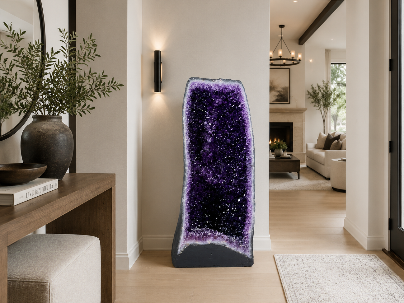 A large freestanding amethyst geode sculpture with a deep purple crystal interior and dark gray base, displayed in a modern home entryway.