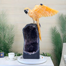 Decorative piece with a parrot on a geode-like structure against a neutral background