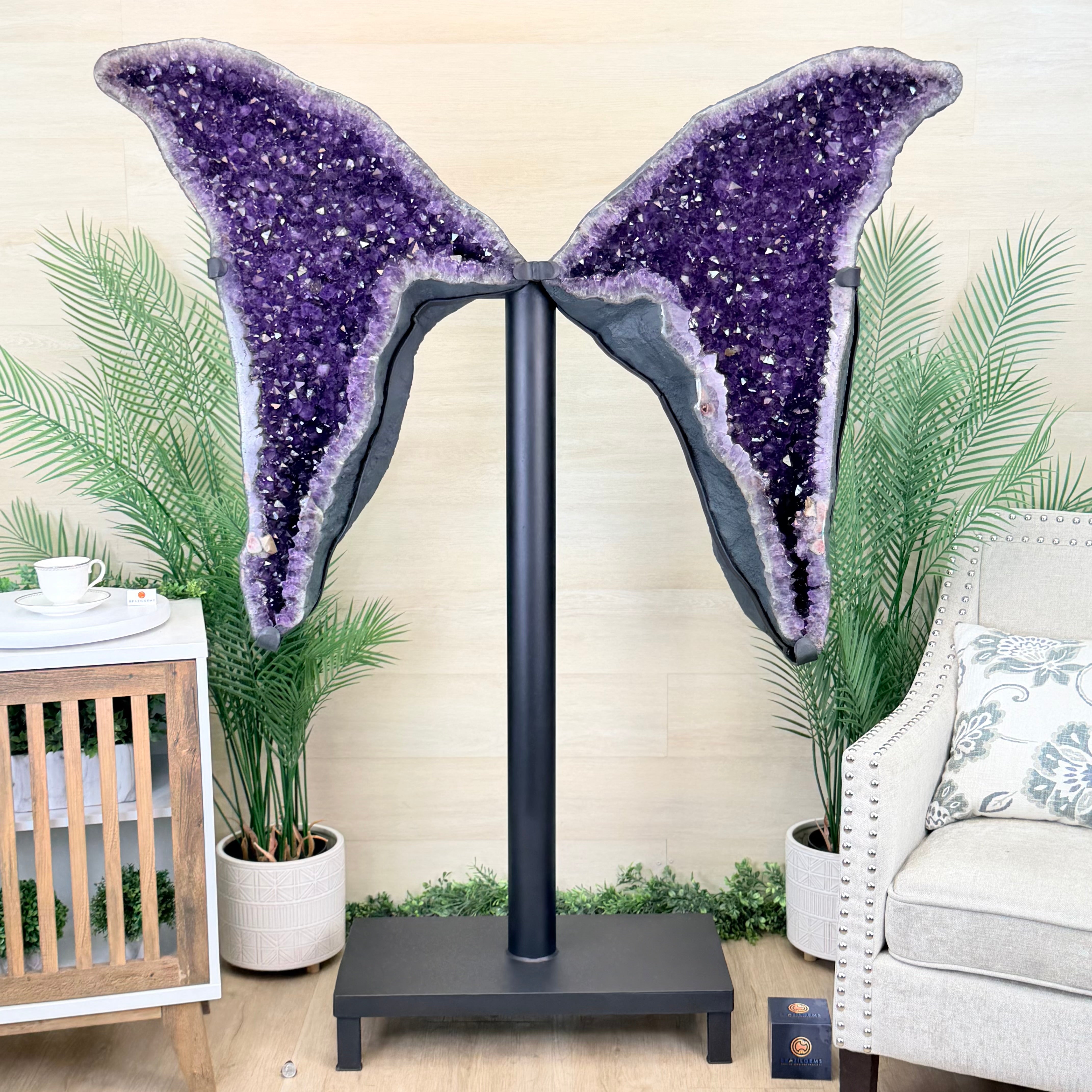Decorative purple geode sculpture on a stand in a home setting with plants and furniture.