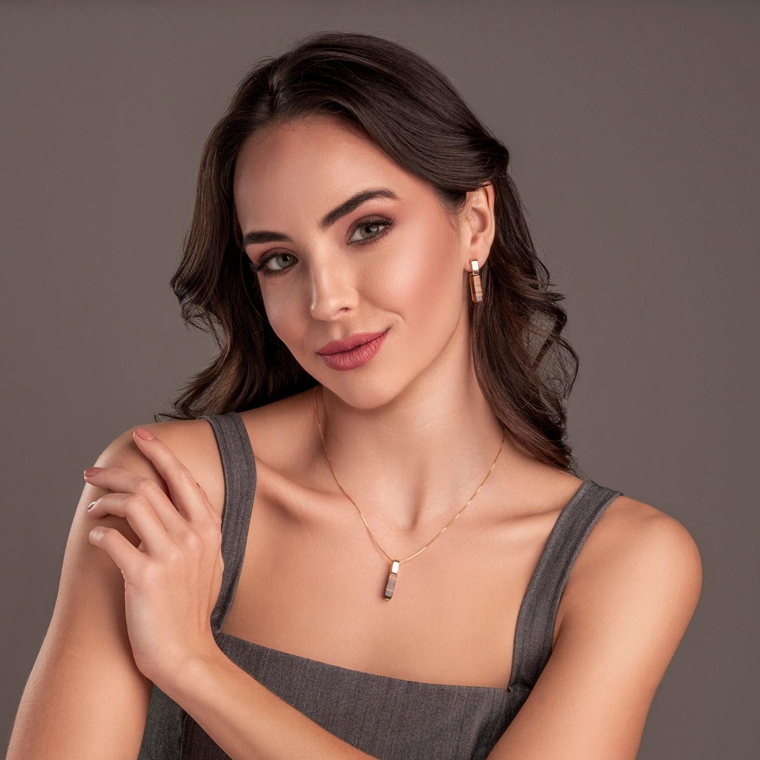 Woman wearing a gray tank top against a plain background