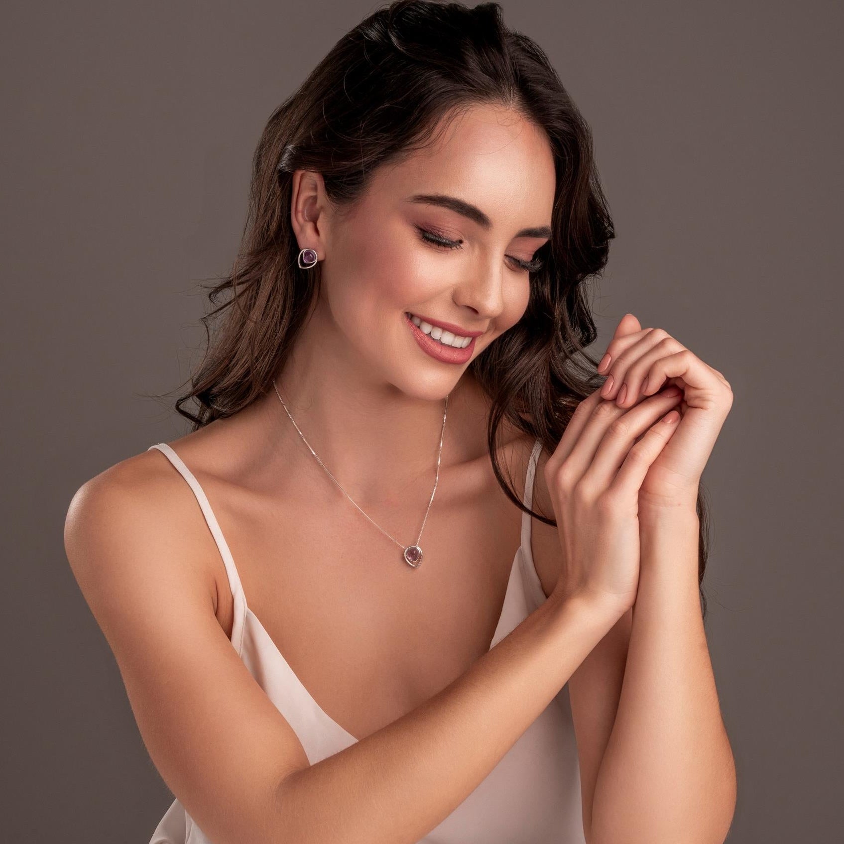 Woman wearing a necklace against a neutral background