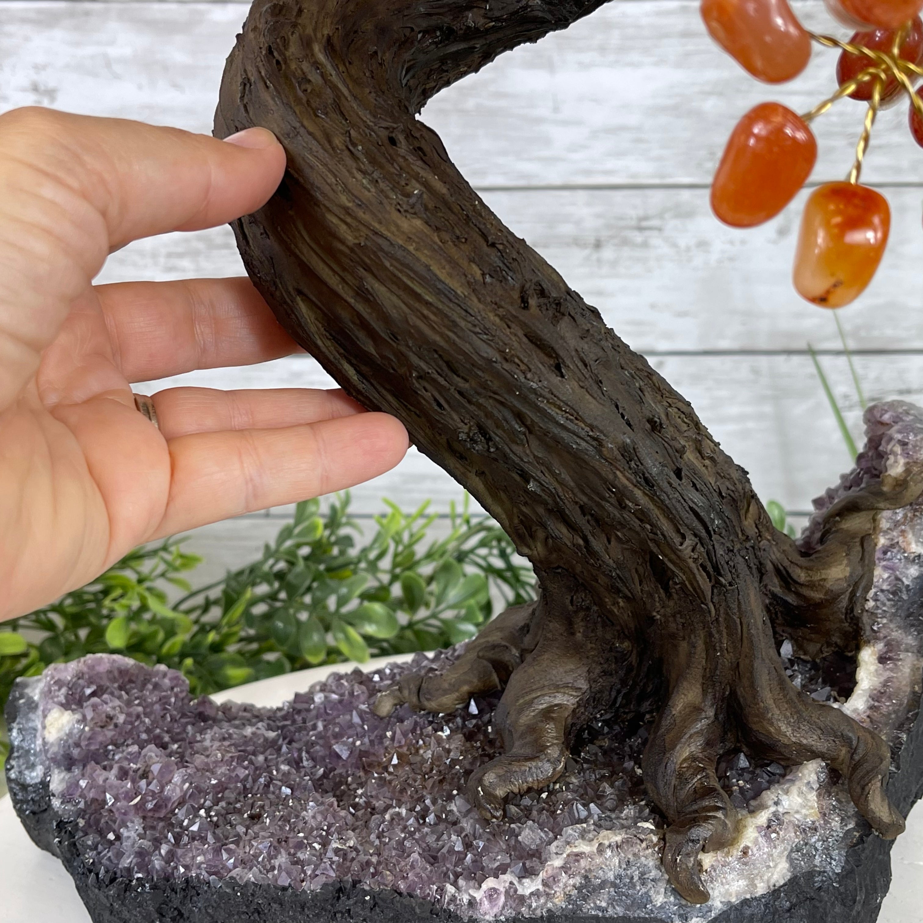 Hand holding the Carnelian Gemstone Tree with an Amethyst base