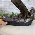 A hand holding a handmade tree sculpture made of Carnelian gemstones