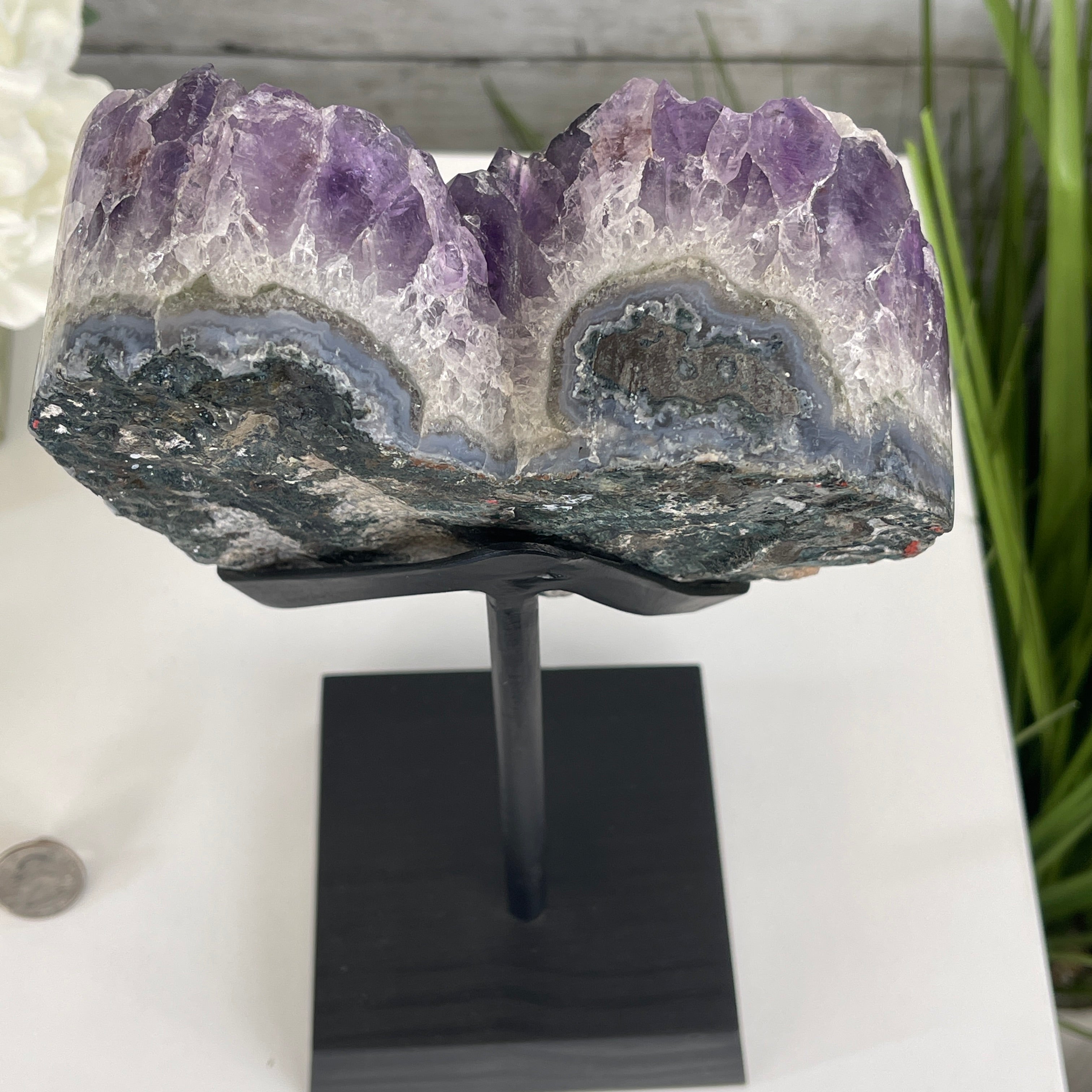 Amethyst heart geode placed on a black stand