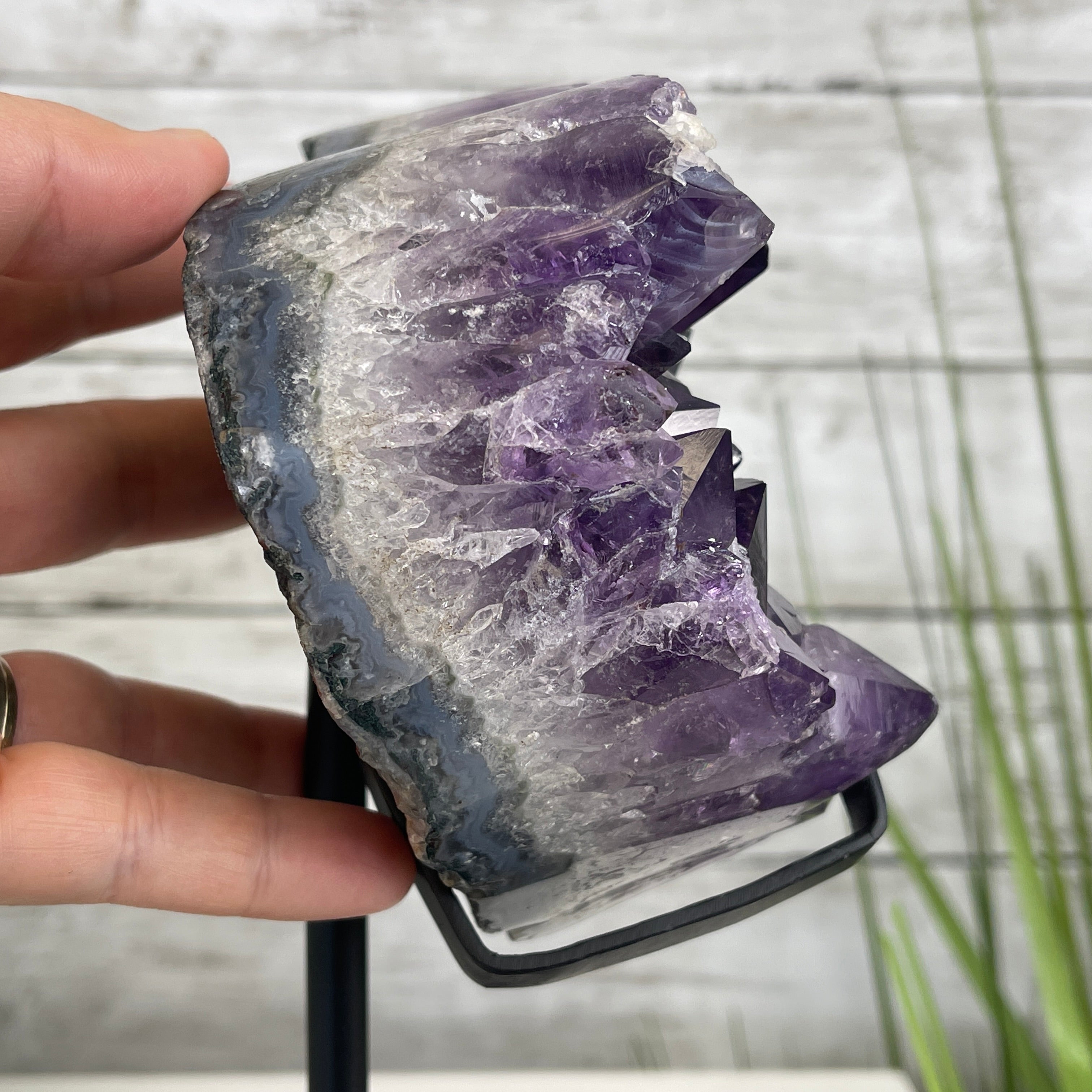 Individual holding a purple amethyst heart geode
